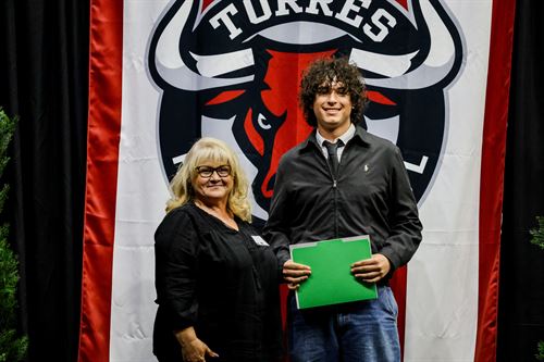 Foundation board member standing next to a male Decathlon scholarship recipient.